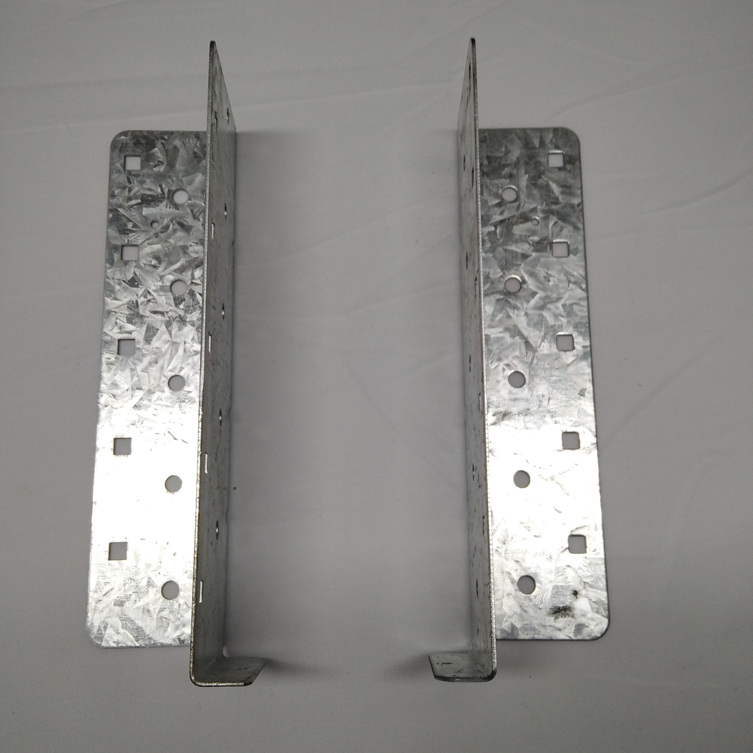 The Surealong split joist hanger is a two‑piece, width‑adjustable joist hanger that can accommodate joist widths from 60mm and 220mm. Each Surealong split joist hanger is comprised of one left and one right piece. It is essential to install nails in the b